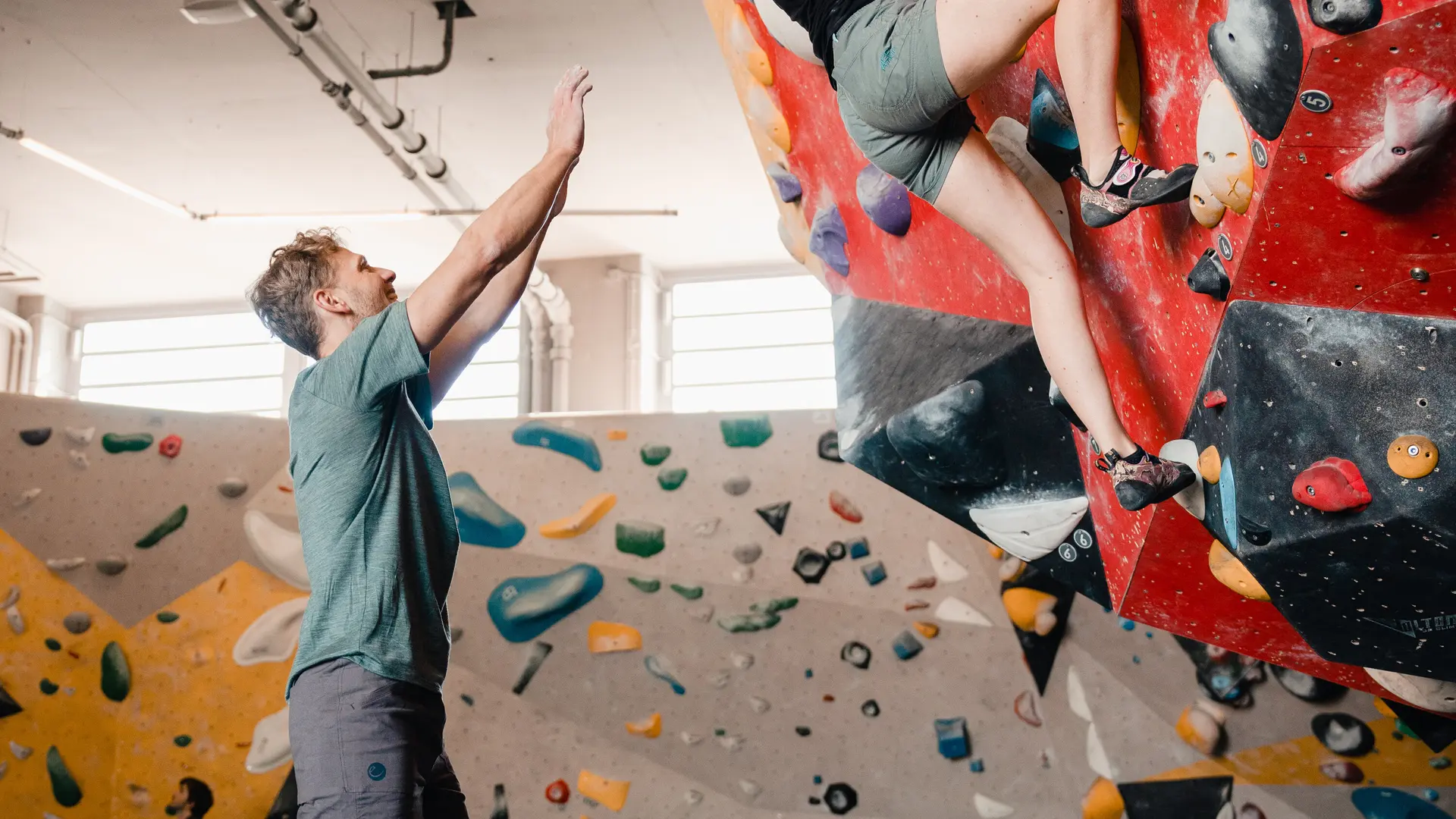 Eine Frau klettert in einer Kletterhalle, ihr Partner sichert sie. | © DAV/Marisa Koch