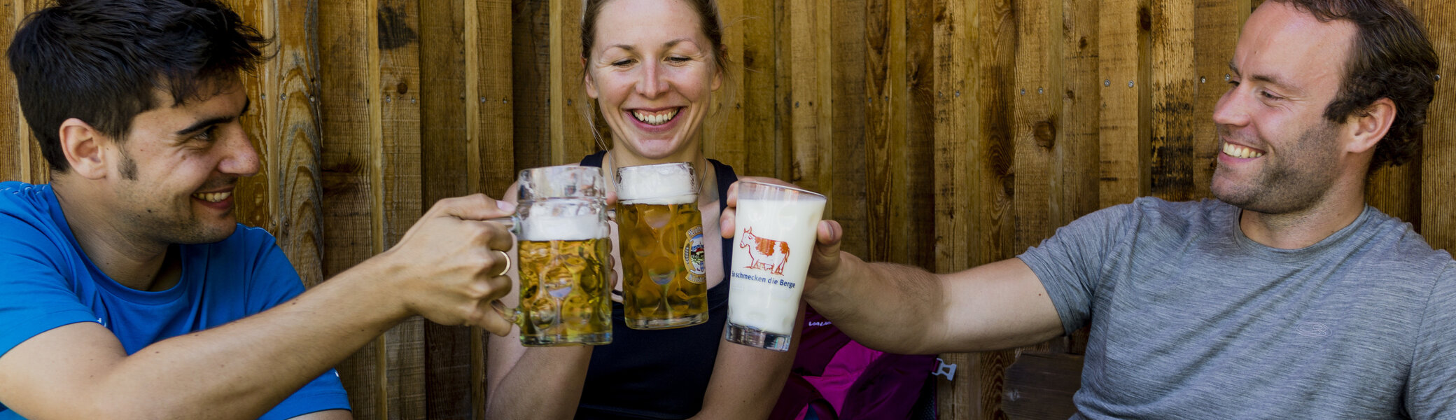 Auf der Hütte: Drei Personen stoßen mit Bierkrügen an | © DAV/Hans Herbig
